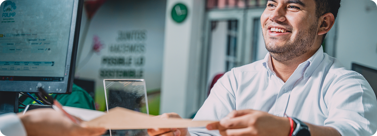 Colaborador de Ciudad Limpia atiende a una persona en un punto de servicio y recibe un documento, en un ambiente de atención amable y cercana.