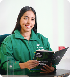 Colaboradora de Ciudad Limpia, sentada en un punto de atención, sostiene una libreta institucional y mira a la cámara con una expresión amable.