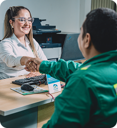 Colaboradora de Ciudad Limpia saluda con un apretón de manos a un usuario en un punto de atención, en un ambiente cercano y de servicio.